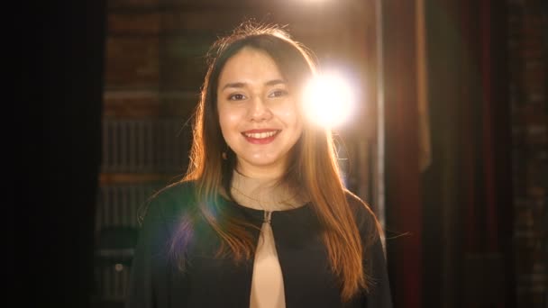 Splendida ragazza in cappotto nero indoor guardando la fotocamera e sorridendo — Video Stock