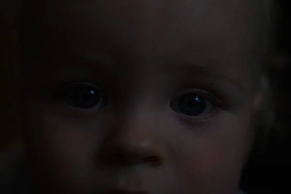 Sad eyes baby in darkness. — Stock Photo, Image