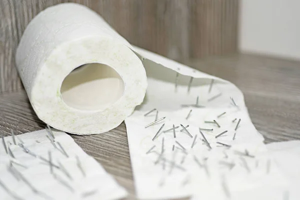 Toilet paper with nails in it. — Stock Photo, Image