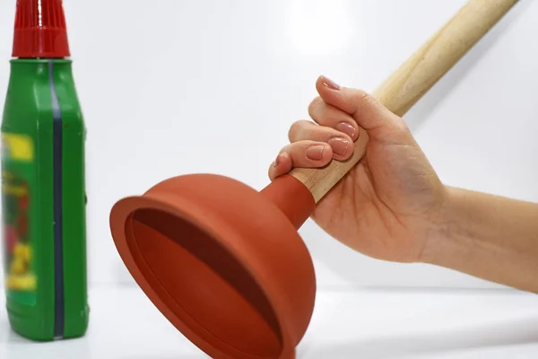 Woman with plunger trying to remove clogged sinks. — Stock Photo, Image