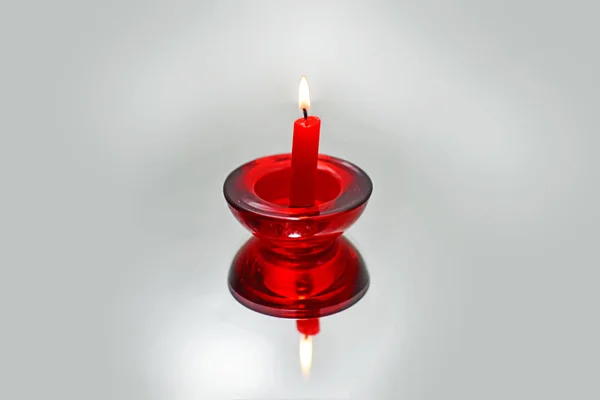Red candle on mirror with reflection. — Stock Photo, Image