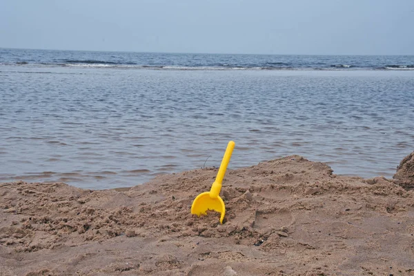 Pelle jouet jaune dans le sable . — Photo