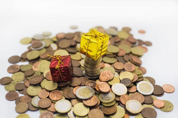 Monedas en euros y pequeños regalos decorativos . — Foto de Stock