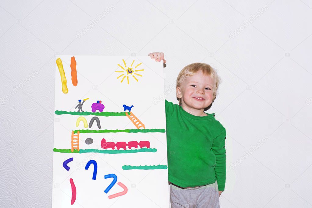 Small smiling boy with Play Clay board.