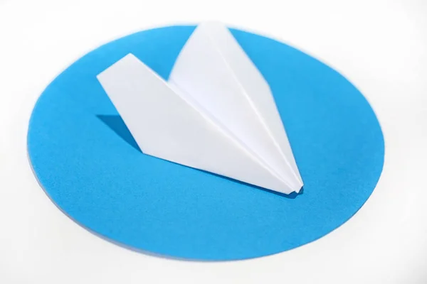 Біла паперова площина на круглому синьому колі . — стокове фото