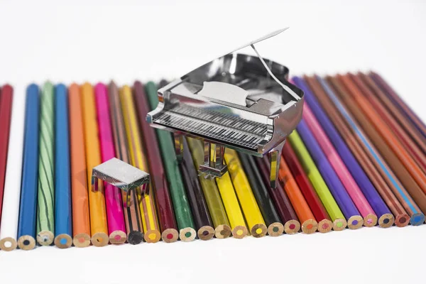 Pequeño piano de metal con libro de notas . — Foto de Stock