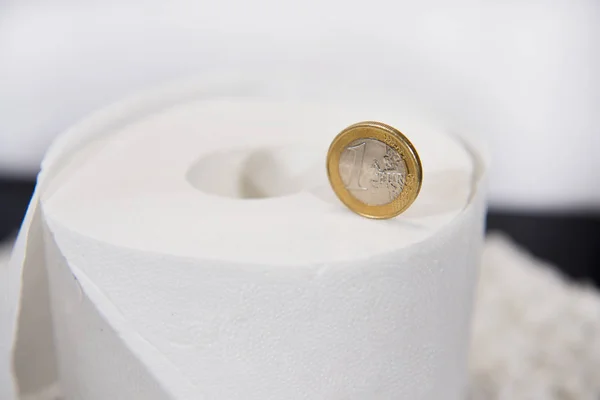 Abstraktní fotografie s konceptem toaletního papíru. Euro mince na bílém toaletním papíru role. — Stock fotografie