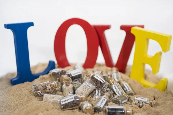 Glas-Reagenzglas mit Sand verschiedener Sommerurlaubsziele. Urlaubszeit abstraktes Foto. — Stockfoto