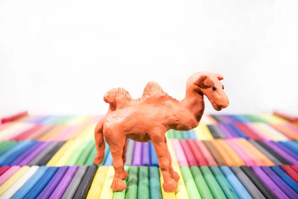 Hrát hliněná zvířata. Velbloud na barevném pozadí. — Stock fotografie