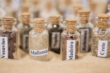 Farklı yaz tatili ülkelerinin kumlu cam test tüpü..