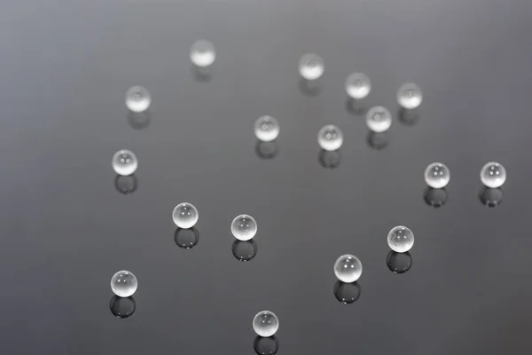 Foto abstracta con pequeñas bolas de vidrio sobre fondo transparente . — Foto de Stock