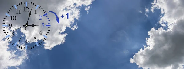 Zomertijd (Dst). Blauwe lucht met witte wolken en klok. Draai de tijd vooruit (+ 1 uur)). — Stockfoto