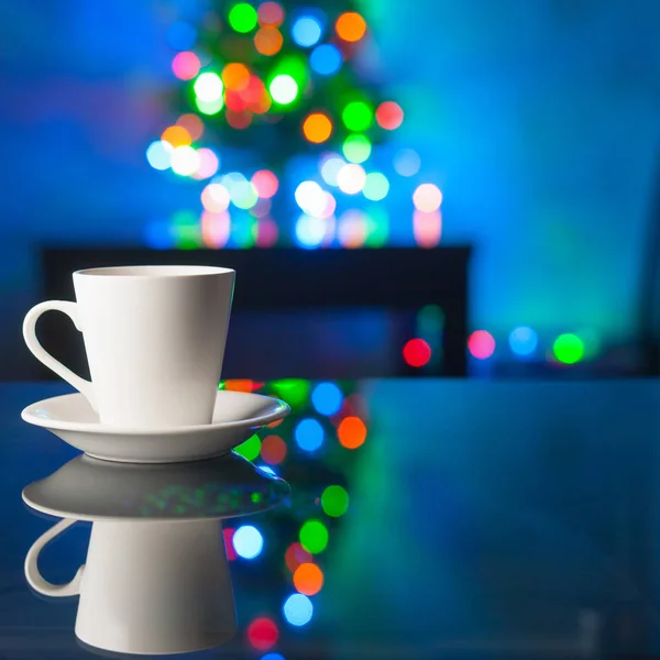 Beyaz kahve fincanı ve tabağı üzerinde arka plan renkli bokeh Cam masaya.