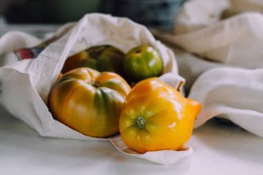 Eko tote çanta mutfak masasının üzerinde sarı domates ile