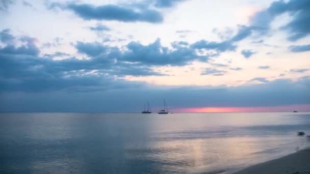 Beautiful sunset on ocean beach. Yachts and boats on a background of red sunset. — Stock Video