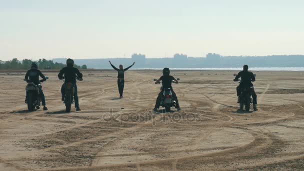 Beaucoup de motocyclistes chevauchant le long de la plage de sable loin. motards glisser course avec fille — Video