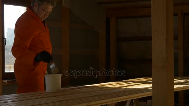 Carpenter malíř zpracuje dřevěný materiál pro stavbu. — Stock video