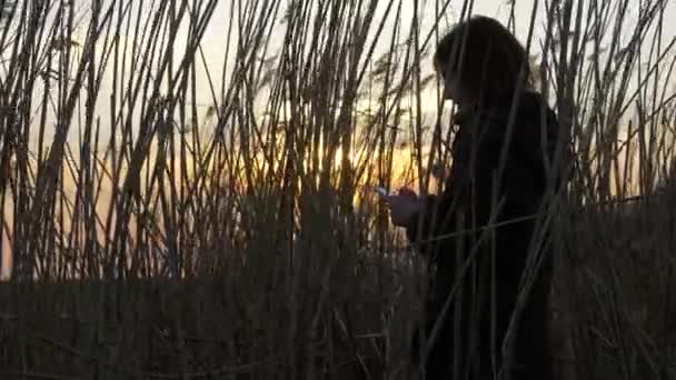 Mooi meisje typt een bericht met een witte kleur-smartphone. — Stockvideo