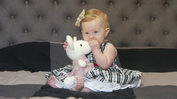 Cute Little Baby Siedzi Łóżku Sukience Uśmiechnięty Zabawka — Wideo stockowe