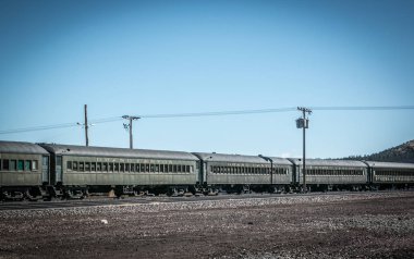 old railway with exclusive wagons at a train station in the middle of the desert in america under a blue sky