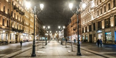 Gece yarısı kar yağarken fenerlerin arasında yaya caddesi