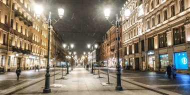 Gece yarısı kar yağarken fenerlerin arasında yaya caddesi