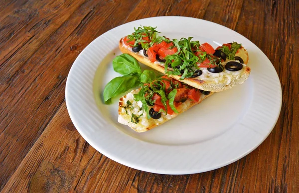 Italian tomato bruschetta with olives on wooden — Stock Photo, Image