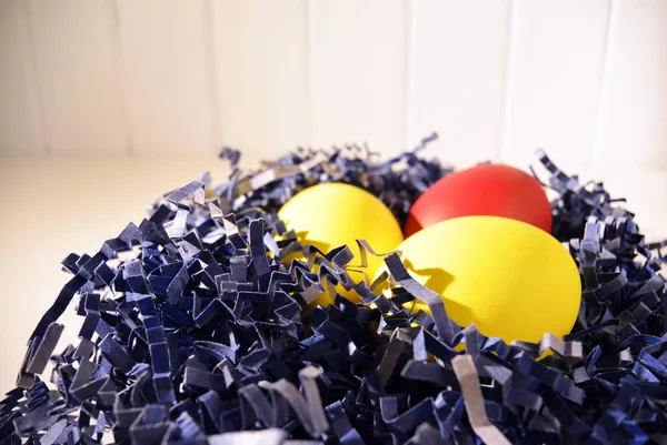 Окрашенные пасхальные яйца в голубую бумагу птичье гнездо на белом — стоковое фото