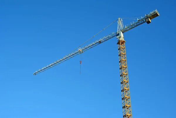 Industrial construction crane against blue sky in the background — Stock Photo, Image