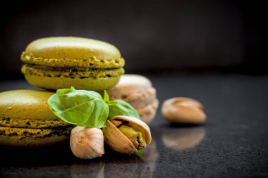 iki fıstık macarons koyu arka plan üzerinde fındık ile