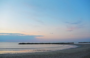 Deşarj kum plajı üzerinde. Deniz üzerinde güzel gündoğumu gökyüzü