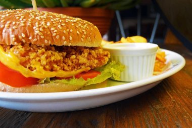 Çıtır tavuk burger marul ve domates üzerinde kapat.