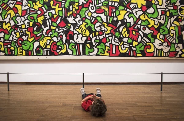 Baby sitting and see on picture on Keith Haring exhibition in Albertina gallery — Stock Photo, Image