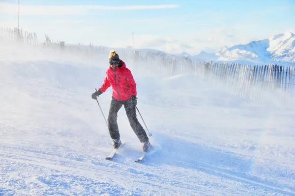 O esquiador em montanhas entre uma nevasca . — Fotografia de Stock