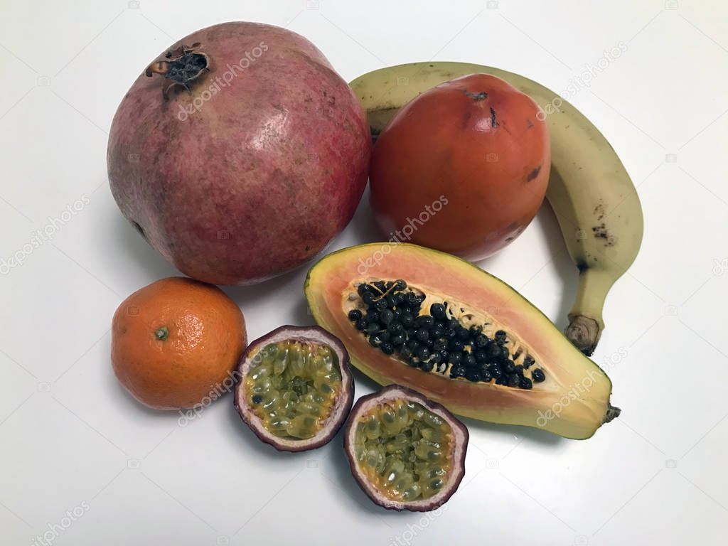 Creative layout of pomegranate, mandarin, banana, sharon, papaya, and passion fruit. The apartment was lying. Food concept.