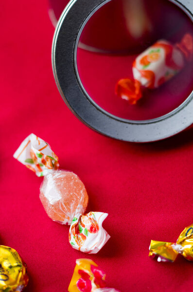 Candies with various flavors inside a tin can and red background