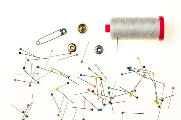 Achtergrond met gekleurde pinnen, wol spool veiligheidsspeld en metaal — Stockfoto