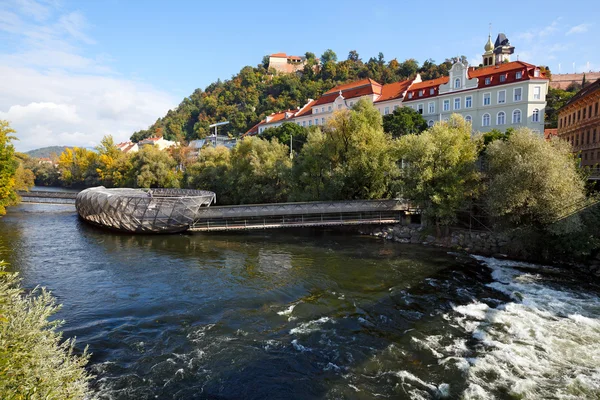 Flussmur mit der künstlichen schwimmenden Plattform Murinsel in der Mitte und alten Gebäuden am Ufer. graz, Österreich. — Stockfoto