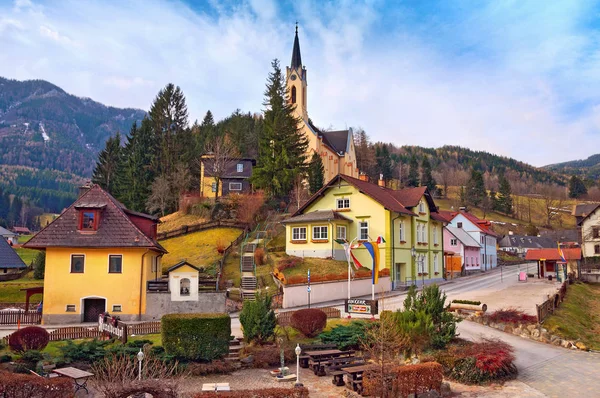 高山村庄对獭兔普赖恩 (德语︰ 普赖恩 der 獭兔) 与天主教教区教堂的圣保禄上一座小山。奥地利. — 图库照片