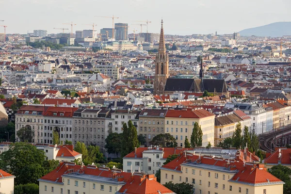 Luftaufnahme der Bezirkslandstraße mit der St.-Otmar-Kirche in der Mitte und vielen Baukränen am Horizont. Wien, Österreich. — Stockfoto