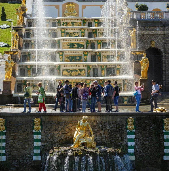 Tourists stand in front of the Grand cascade in the Lower Park of Peterhof (suburb of Saint Petersburg), Russia. — Stock Photo, Image