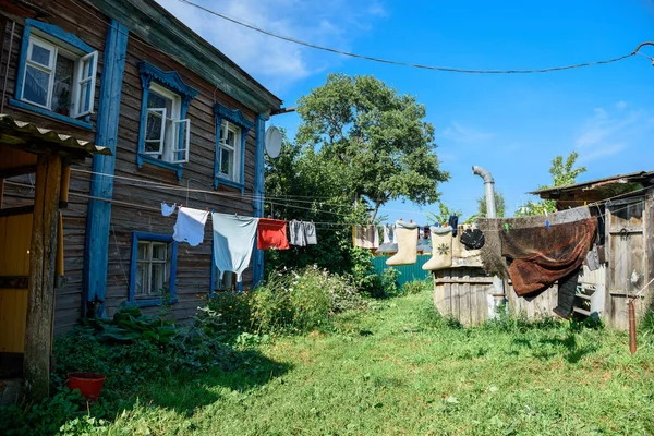 Одежда висит на веревке во дворе старого деревянного жилого дома. Суздаль, Россия — стоковое фото
