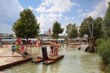 Viyana / Avusturya - 9 Temmuz 2017. Donauinsel su Tuna Adası üzerinde çocuklar için oyun alanı. Tuna Nehri ve St Francis Assisi kilisenin görünümünü. Bölge Donaustadt, Viyana, Avusturya.