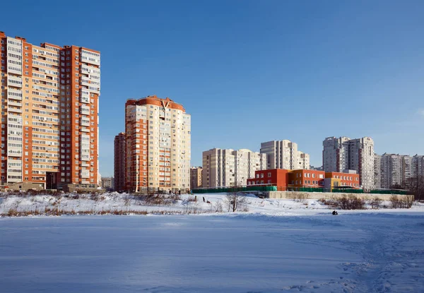 View of the new residential district with kindergarten on the banks of the river Pekhorka in winter. City of Balashikha, Moscow region, Russia.