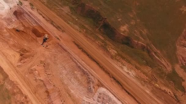 Ore lagring. Grävmaskin laddar malm. Birds eye view. — Stockvideo