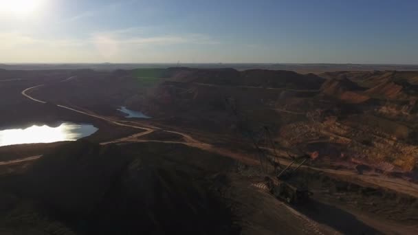 Walking excavator draws ore. Sunset. Birds eye view. — Stock Video