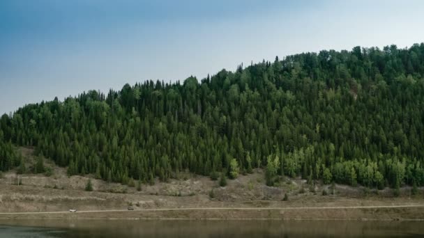 Due jeep cavalcano lungo la strada di montagna. Panorama. Foresta di conifere di montagna. Fiume. Cielo grigio . — Video Stock