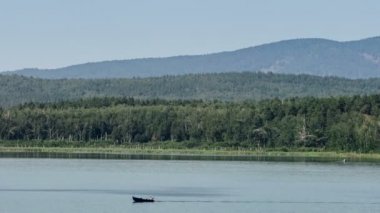 Motorlu tekne ile bir dağ nehir üzerinde gidiyor. Dağ orman. Panorama. Gri gökyüzü. Küçük sis. Haze. Sonbaharda Ural Dağları.
