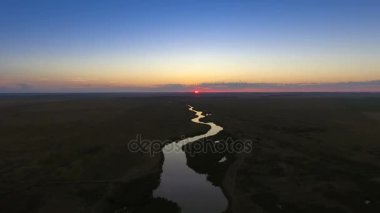 Gün batımında nehir yatağı. Yukarıdan görüntüleyin. Pastoral yolu.