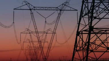 Yüksek gerilim elektrik iletim kulesi enerji pilon. Gün batımı. Isı pus. Timelapse.